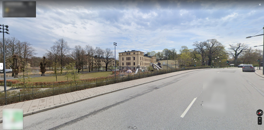 Foto do Google Maps que parece uma escola ao fundo com um playground na frente.  Eu não tenho bem certeza se esse prédio é uma escola.