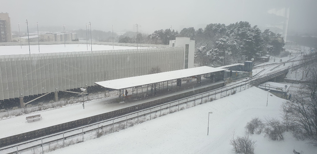Imagem de uma estação de metrô coberta de neve num dia nevando.