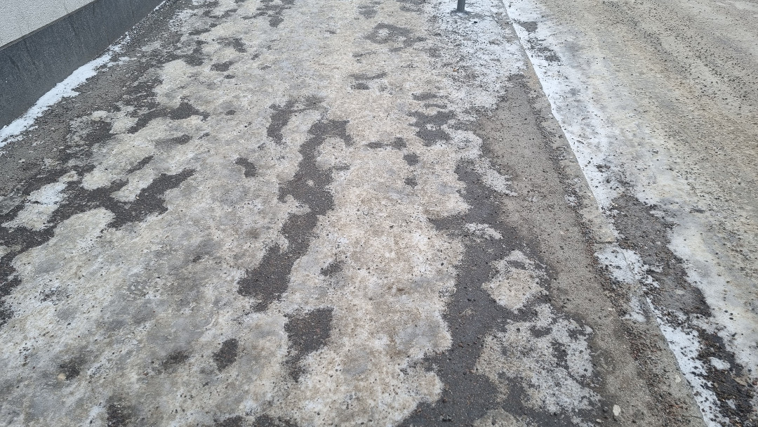 Calçada com neve derretida e suja.